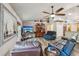 Living room features hardwood floors, leather seating, decoratively-shelved vaulted ceilings and large picture window at 179 Patrice Hope St, Leesburg, FL 34748