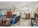 Inviting living room flows into the kitchen, with hardwood floors, leather seating, and decoratively-shelved vaulted ceilings at 179 Patrice Hope St, Leesburg, FL 34748