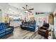 Open-concept living room into kitchen boasts hardwood floors, vaulted ceiling with decorative shelving and comfortable seating at 179 Patrice Hope St, Leesburg, FL 34748