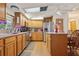 Modern kitchen with wood cabinets and stainless steel appliances next to a dining area at 1901 Brookside Dr, Mount Dora, FL 32757