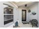 Inviting front porch with a black door, decorative plants, a bench and a window with mini blinds at 1917 Peachtree Ave, The Villages, FL 32162