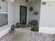 Inviting front porch with a black door, decorative plants, a bench and a window with mini blinds at 1917 Peachtree Ave, The Villages, FL 32162