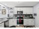 Well-appointed kitchen featuring white cabinets, granite counters, stainless steel appliances, and a modern backsplash at 1917 Peachtree Ave, The Villages, FL 32162