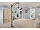 Bedroom featuring a canopy bed, large wardrobe, TV, and ensuite bathroom with walk-in shower and decorative ceiling fan at 1917 Peachtree Ave, The Villages, FL 32162