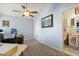 This room features a ceiling fan, neutral colors, and a peek into an on-suite half bath at 1917 Peachtree Ave, The Villages, FL 32162