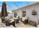 Inviting covered patio with comfortable seating, brick flooring, and a cozy fire pit centerpiece at 1917 Peachtree Ave, The Villages, FL 32162