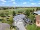 Stunning aerial view of a home situated on a golf course with a serene lake and mature trees at 1992 Hagood Loop, The Villages, FL 32162