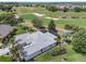 Aerial view of home's rear exterior, gorgeous landscaping, and proximity to the golf course at 1992 Hagood Loop, The Villages, FL 32162