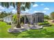 Well maintained backyard featuring a screened-in lanai, decorative rock gardens, and lush green lawn at 1992 Hagood Loop, The Villages, FL 32162