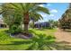 Spacious backyard featuring lush landscaping, a screened-in lanai, and a manicured lawn at 1992 Hagood Loop, The Villages, FL 32162