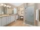 Luxurious bathroom with double vanity, granite counters, and glass shower at 1992 Hagood Loop, The Villages, FL 32162