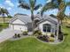 Lovely home featuring a lush lawn, mature landscaping, and a paver driveway at 1992 Hagood Loop, The Villages, FL 32162