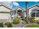 Inviting front entrance showcasing a well-manicured lawn and a charming, decorative front door at 1992 Hagood Loop, The Villages, FL 32162