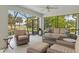 Screened lanai with comfortable wicker furniture and view of the golf course at 1992 Hagood Loop, The Villages, FL 32162