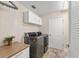 Laundry room with side-by-side washer and dryer and built-in cabinets for ample storage at 1992 Hagood Loop, The Villages, FL 32162
