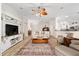 Open-concept living room showcasing light wood floors, neutral-toned furniture, and a decorative ceiling fan at 1992 Hagood Loop, The Villages, FL 32162