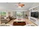 Comfortable living room with a ceiling fan, light wood floors, and a large built-in television stand at 1992 Hagood Loop, The Villages, FL 32162