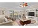 Living room featuring ceiling fan, view to outdoor living space and custom built-in shelving at 1992 Hagood Loop, The Villages, FL 32162