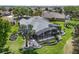 Backyard view of home showcasing the screened lanai, landscaping, and well-maintained lawn at 1992 Hagood Loop, The Villages, FL 32162