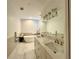 Bright bathroom featuring double sinks, a soaking tub, marble flooring, and contemporary fixtures at 2261 Osprey Ave, Orlando, FL 32814