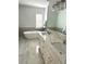 Bright bathroom featuring double sinks, a soaking tub, marble flooring, and contemporary fixtures at 2261 Osprey Ave, Orlando, FL 32814