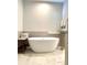 Stylish bathroom featuring a freestanding tub, a tiled accent wall, and plantation shutters at 2261 Osprey Ave, Orlando, FL 32814