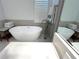 Stylish bathroom featuring a freestanding tub, a tiled accent wall, and plantation shutters at 2261 Osprey Ave, Orlando, FL 32814