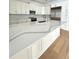 Modern kitchen with white cabinets, an expansive island, quartz countertop, stainless steel appliances, and hardwood flooring at 2261 Osprey Ave, Orlando, FL 32814