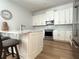 A modern kitchen with white cabinetry, stainless steel appliances, a marble counter top, and a kitchen island with bar stool seating at 2261 Osprey Ave, Orlando, FL 32814