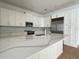Spacious kitchen features custom white cabinets, stainless steel appliances, quartz countertops, and modern backsplash at 2261 Osprey Ave, Orlando, FL 32814