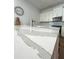 Close-up of a kitchen island featuring a beautiful marble counter top, stainless steel faucet, and a modern clock on the wall at 2261 Osprey Ave, Orlando, FL 32814