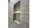 Close up of the shower niche with gray tile and white shelf at 2261 Osprey Ave, Orlando, FL 32814