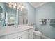 Well-lit bathroom with a large mirror, vanity, toilet, and a shower with a glass door at 2471 Yalaha Ave, The Villages, FL 32162