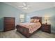 Comfortable bedroom with a wooden bed frame, matching dressers and light-colored floors at 2471 Yalaha Ave, The Villages, FL 32162