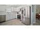 Well-equipped kitchen featuring stainless steel appliances, white cabinetry, and ample counter space at 2471 Yalaha Ave, The Villages, FL 32162