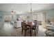 Open-concept living room with dining area, light wood floors, slider to patio, and comfortable seating at 2471 Yalaha Ave, The Villages, FL 32162