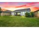Large backyard with lush green grass, lovely landscaping and view of the water at 251 Blue Cypress Dr, Groveland, FL 34736