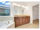 Bathroom with a double vanity, soaking tub, and a large window providing natural light at 251 Blue Cypress Dr, Groveland, FL 34736