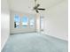 Bright bedroom with a ceiling fan, light-colored carpet, and large windows showcasing a beautiful view at 251 Blue Cypress Dr, Groveland, FL 34736