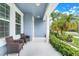 Inviting front porch with comfortable seating and views of the lush landscaping and beautiful blue painted facade at 251 Blue Cypress Dr, Groveland, FL 34736