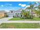 Charming single-story home featuring a well-manicured lawn, a two-car garage and beautiful tropical landscaping at 251 Blue Cypress Dr, Groveland, FL 34736