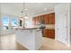 Modern kitchen featuring an island with granite countertops, stainless steel appliances, and bright natural light from large windows at 251 Blue Cypress Dr, Groveland, FL 34736
