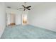 Spacious main bedroom featuring a ceiling fan, light-colored carpet, and access to the bathroom at 251 Blue Cypress Dr, Groveland, FL 34736