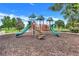 Community playground featuring slides, stairs, and covered platforms in a mulch-covered area at 251 Blue Cypress Dr, Groveland, FL 34736
