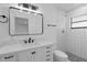 A renovated bathroom has a modern sink and white tile shower at 2517 Royal Palm Dr, Edgewater, FL 32141