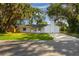 Inviting single-story home features a freshly painted white exterior, well-manicured lawn, and shade trees at 2517 Royal Palm Dr, Edgewater, FL 32141