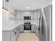 This kitchen features gray cabinets, stainless steel appliances, and a light countertop at 2517 Royal Palm Dr, Edgewater, FL 32141