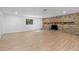 Open-concept living area showcases wood-look floors, a brick fireplace, and natural light at 2517 Royal Palm Dr, Edgewater, FL 32141