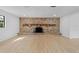 Spacious living area featuring wood-look floors and a grand brick fireplace at 2517 Royal Palm Dr, Edgewater, FL 32141