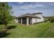 The backyard features a screened-in lanai and lush landscaping, perfect for relaxing and entertaining at 25962 High Hampton Cir, Sorrento, FL 32776